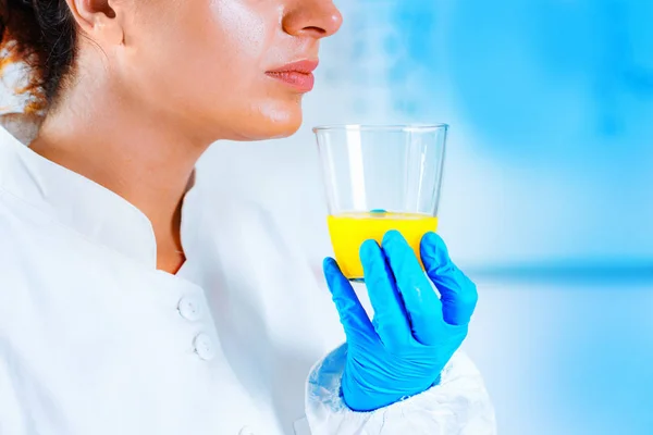 cientista realizando a análise sensorial de um suco de laranja