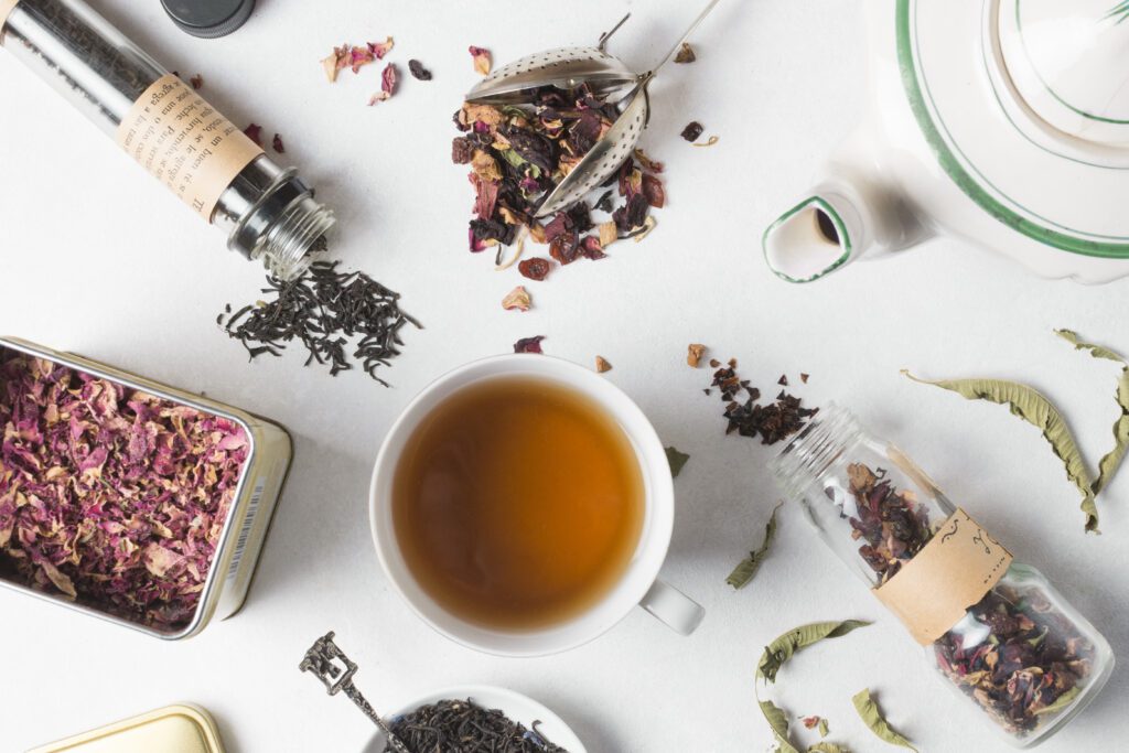 overhead view herbal tea with different types herbs white backdrop