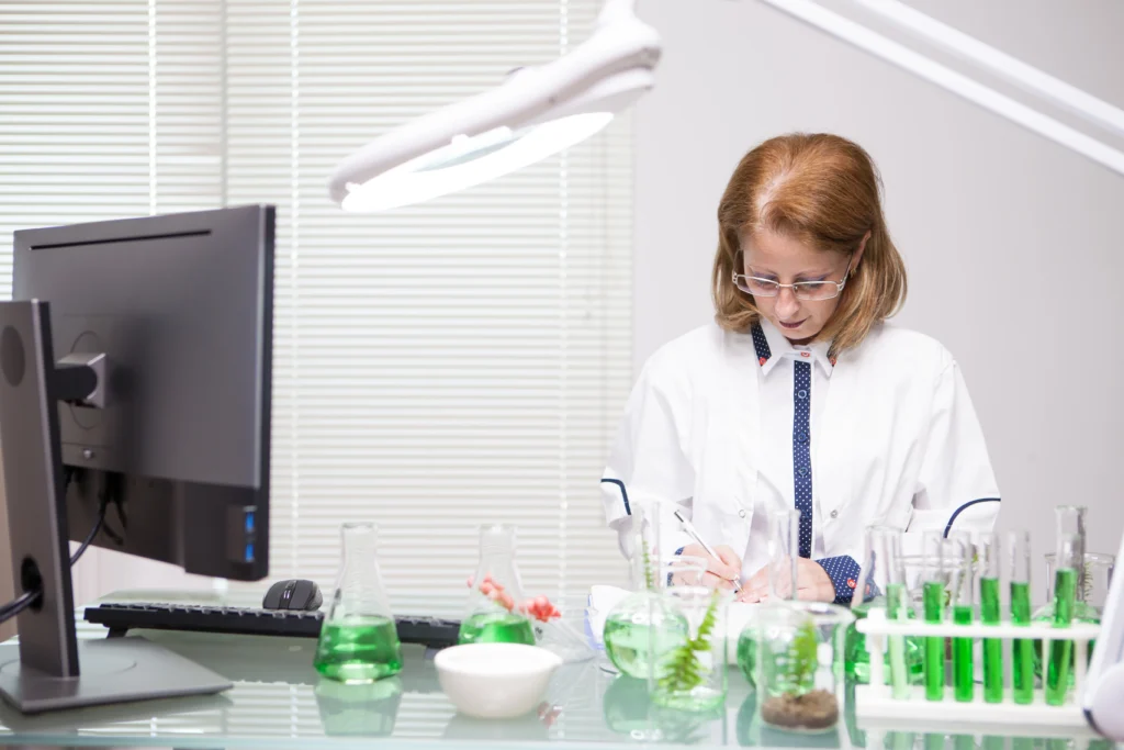 focused middle age woman taking notes after scientific test production laboratory biologist working