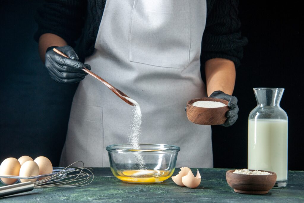 front view female cook pouring flour into eggs dough dark pastry cake pie bakery worker cuisine job 1