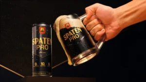 spaten pro na lata e o líquido da mesma em uma caneca